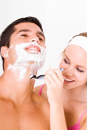 shaving man woman - Close-up of a young woman shaving a mid adult man's face Stock Photo - Premium Royalty-Free, Code: 625-00901387