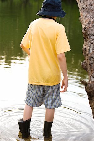 Rear view of a boy standing in water Stock Photo - Premium Royalty-Free, Code: 625-00901412