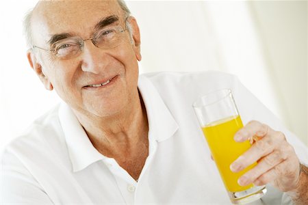 Portrait of a senior man holding a glass of juice Stock Photo - Premium Royalty-Free, Code: 625-00901455