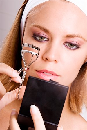 rizador de pestañas - Close-up of a young woman using an eyelash curler Foto de stock - Sin royalties Premium, Código: 625-00901506