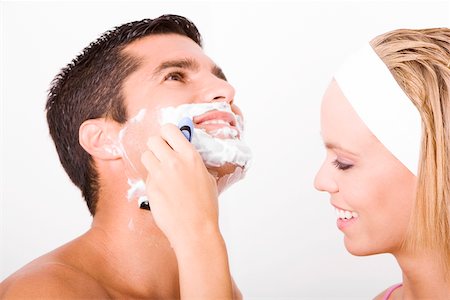 shaving man woman - Close-up of a young woman shaving a mid adult man's face Stock Photo - Premium Royalty-Free, Code: 625-00901500