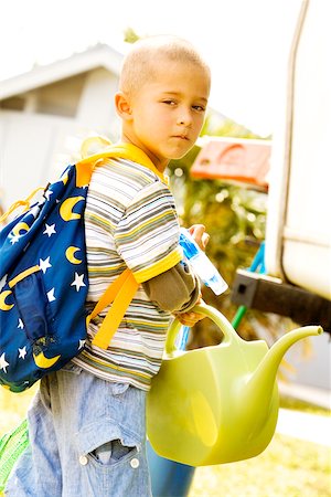 Portrait of a boy holding a watering can Stock Photo - Premium Royalty-Free, Code: 625-00901698