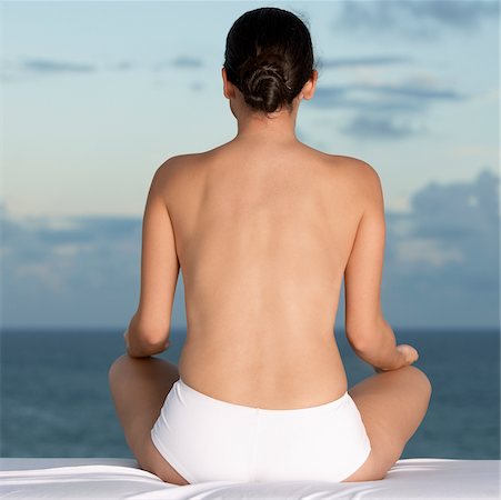 simsearch:625-00839293,k - Rear view of a young woman sitting in a lotus position Stock Photo - Premium Royalty-Free, Code: 625-00901868