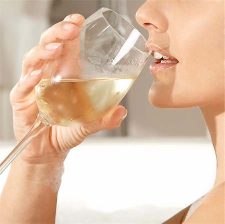 Gros plan d'une jeune femme tenant un verre de vin dans une baignoire Photographie de stock - Premium Libres de Droits, Code: 625-00901945