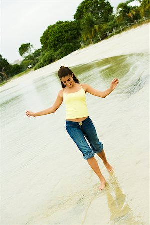 Girl wading in water on the beach Stock Photo - Premium Royalty-Free, Code: 625-00901987