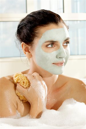 simsearch:625-00902133,k - Close-up of a young woman with a facial mask holding a bath sponge Foto de stock - Royalty Free Premium, Número: 625-00902088