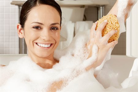 sponge bath woman - Portrait of a young woman using a bath sponge on her arm Stock Photo - Premium Royalty-Free, Code: 625-00902222