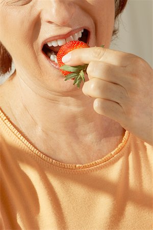 simsearch:625-01096495,k - Mid section view of a senior woman eating a strawberry Stock Photo - Premium Royalty-Free, Code: 625-00902334