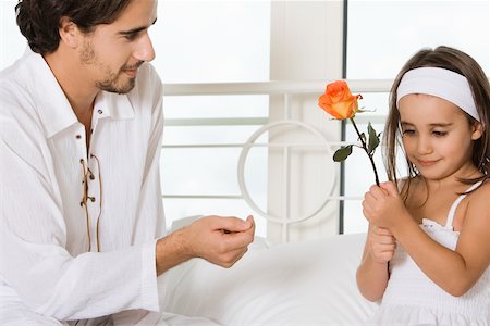 Close-up of a young man looking at his daughter holding a flower Stock Photo - Premium Royalty-Free, Code: 625-00902348