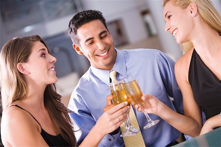 simsearch:640-03265721,k - Two young women and a mid adult man toasting Foto de stock - Sin royalties Premium, Código: 625-00902341