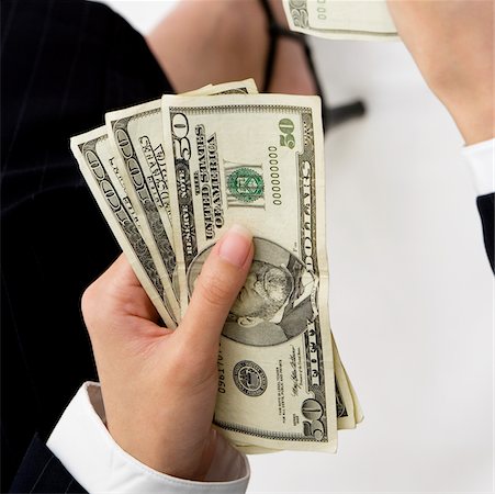Close-up of a businesswoman's hand holding American dollar bills Fotografie stock - Premium Royalty-Free, Codice: 625-00902431