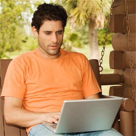 porch swing images - Close-up of a mid adult man using a laptop Foto de stock - Sin royalties Premium, Código: 625-00902470