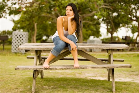 simsearch:625-01747375,k - Young woman sitting on a bench with her hand under her chin Stock Photo - Premium Royalty-Free, Code: 625-00902472