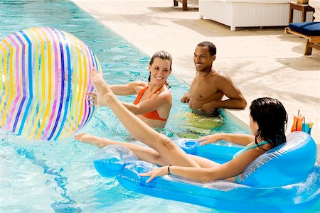 High angle view of two young women and a young man in a swimming pool Foto de stock - Sin royalties Premium, Código: 625-00902489