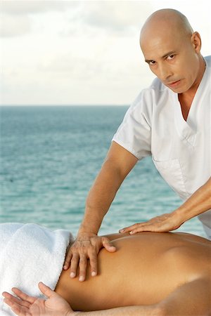 Portrait of a mature man giving a man a back massage Stock Photo - Premium Royalty-Free, Code: 625-00902502