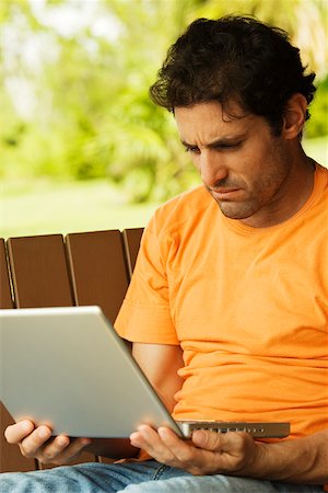 porch swing images - Close-up of a mid adult man looking at a laptop Foto de stock - Sin royalties Premium, Código: 625-00902683