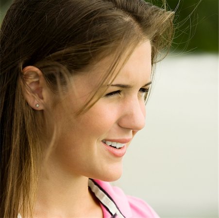 Side profile of a teenage girl smiling Stock Photo - Premium Royalty-Free, Code: 625-00902742