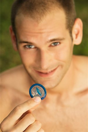 simsearch:625-00851085,k - Portrait of a young man holding a condom Foto de stock - Royalty Free Premium, Número: 625-00902778