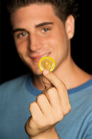 simsearch:625-00851085,k - Portrait of a young man holding a condom Foto de stock - Royalty Free Premium, Número: 625-00902914