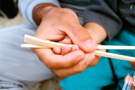 Close-up of a father teaching his son the use of chopsticks, Okinawa, Japan Foto de stock - Sin royalties Premium, Código: 625-00903656