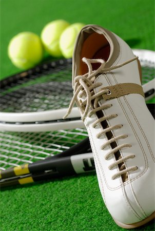 Close-up of a tennis shoe with tennis rackets and tennis balls Stock Photo - Premium Royalty-Free, Code: 625-01037826