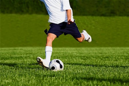 Low section view of a soccer player playing soccer Stock Photo - Premium Royalty-Free, Code: 625-01038036