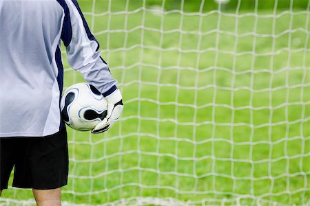 soccer goalkeeper backside - Rear view of a goalie holding a soccer ball Stock Photo - Premium Royalty-Free, Code: 625-01038113