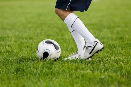 Low section view of a soccer player with a soccer ball Stock Photo - Premium Royalty-Free, Code: 625-01038183