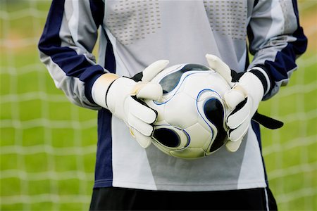 Mid section view of a goalie holding a soccer ball Stock Photo - Premium Royalty-Free, Code: 625-01038207