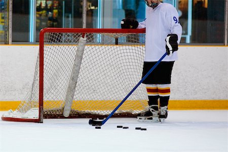 simsearch:625-01038051,k - Close-up of an ice hockey player standing in front of a goal post Stock Photo - Premium Royalty-Free, Code: 625-01038364