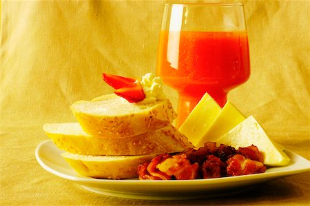 simsearch:625-00898861,k - Gros plan des tranches de pain et de fromage avec un verre de jus sur une plaque Photographie de stock - Premium Libres de Droits, Code: 625-01038623