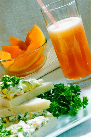 simsearch:625-00898861,k - Gros plan d'un verre de jus et un bol de salade de fruits avec un sandwich sur un plateau Photographie de stock - Premium Libres de Droits, Code: 625-01038647