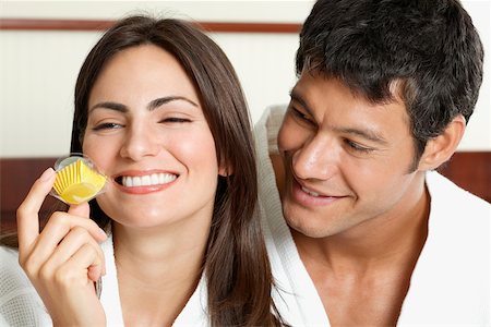 Close-up of a young woman holding a cupcake with a mid adult man looking at her Stock Photo - Premium Royalty-Free, Code: 625-01038856