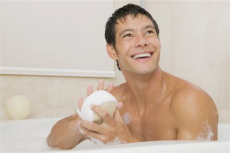 simsearch:625-01261019,k - Gros plan d'un jeune homme tenant un loofah dans une baignoire Photographie de stock - Premium Libres de Droits, Code: 625-01038914