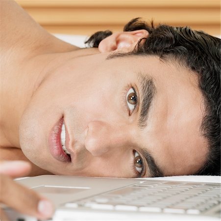 simsearch:640-01357111,k - Portrait of a young man lying near a laptop Foto de stock - Sin royalties Premium, Código: 625-01038944