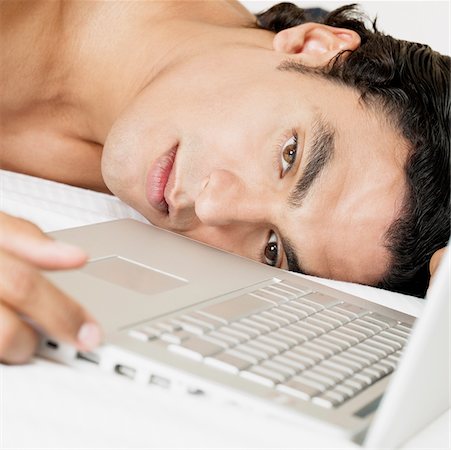 simsearch:640-01357111,k - Close-up of a young man lying near a laptop Foto de stock - Sin royalties Premium, Código: 625-01038956