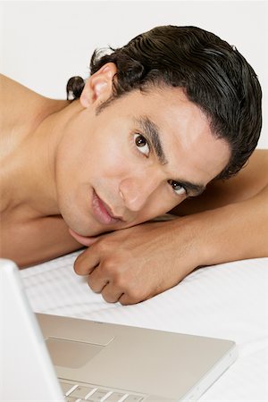 simsearch:640-01357111,k - Portrait of a young man lying in front of a laptop Foto de stock - Sin royalties Premium, Código: 625-01038969