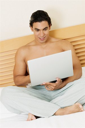Young man using a laptop Stock Photo - Premium Royalty-Free, Code: 625-01038986
