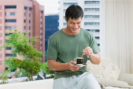 Mid adult man stirring tea with a teaspoon Stock Photo - Premium Royalty-Free, Code: 625-01038990