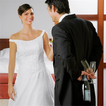 simsearch:625-01263048,k - Bräutigam seine Braut zu betrachten und hält eine Flasche und Gläser hinter seinem Rücken Stockbilder - Premium RF Lizenzfrei, Bildnummer: 625-01039011