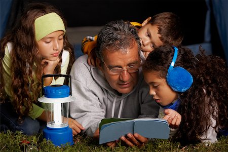 simsearch:632-02744729,k - Senior man reading a book to his three grandchildren Stock Photo - Premium Royalty-Free, Code: 625-01039088