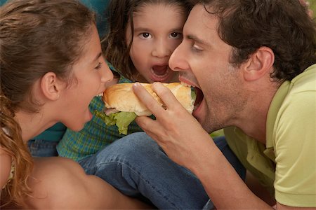 people eating hot dogs - Close-up of a family eating hot dogs Stock Photo - Premium Royalty-Free, Code: 625-01039138