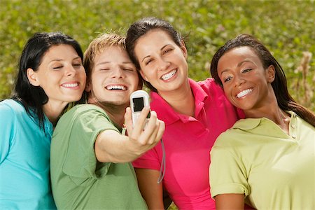 Close-up of three young women and a young man photographing themselves Stock Photo - Premium Royalty-Free, Code: 625-01039190