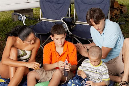 Gros plan d'une jeune femme et un homme adult moyen assis avec leurs deux enfants Photographie de stock - Premium Libres de Droits, Code: 625-01039233