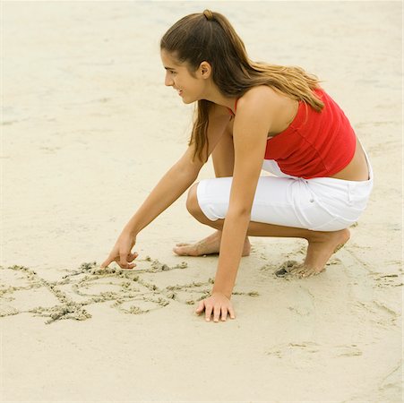 simsearch:625-00902214,k - Close-up of a girl drawing in sand on the beach Stock Photo - Premium Royalty-Free, Code: 625-01039249