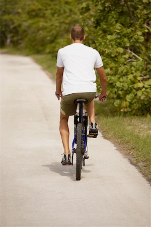 simsearch:625-01095436,k - Rear view of a young man riding a bicycle Stock Photo - Premium Royalty-Free, Code: 625-01039276