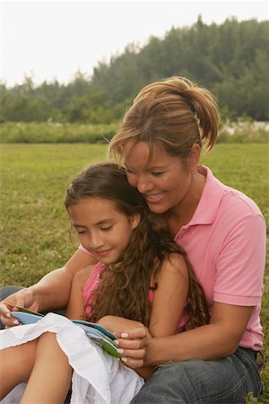 Femme mature et sa fille lisant un livre dans le parc Photographie de stock - Premium Libres de Droits, Code: 625-01039282