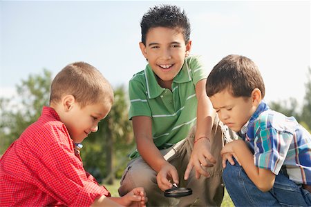 simsearch:695-03388823,k - Portrait of a boy holding a magnifying glass with his friends beside him Stock Photo - Premium Royalty-Free, Code: 625-01039387