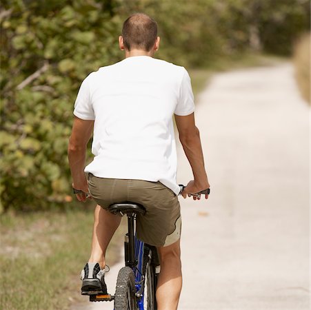 simsearch:625-00802074,k - Rear view of a young man riding a bicycle Foto de stock - Sin royalties Premium, Código: 625-01039656