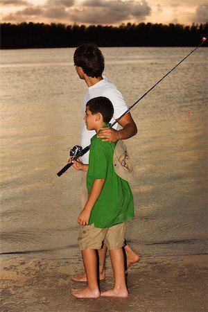 Premium Photo  Active man and teenage boy with rods fishing by